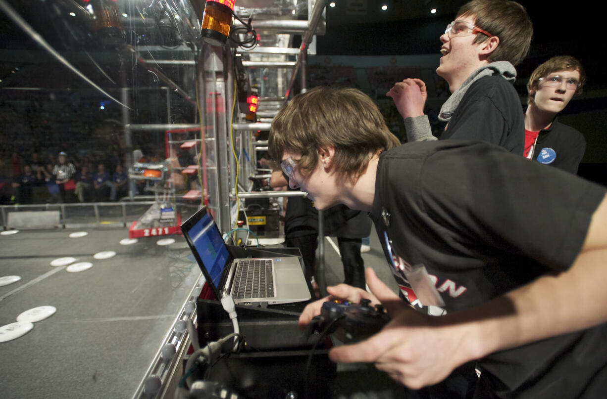 Mean Machine members (from left) co-pilot Ryan Berg, 16; commander/team captain Keefe Koenig, 18; and pilot Bryce Croucher, control their disc-shooting robot in Friday's regional challenge at Veterans Memorial Coliseum in Portland.