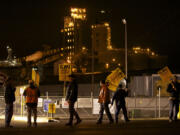 ILWU workers picket Wednesday evening in front of the Port of Vancouver's Gate 2 with grain terminals in the background.