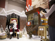 Tina Stokes takes a picture of her daughter, Calista Stokes, 6, with Santa on Saturday at the Festival of Trees at Pearson Air Museum.