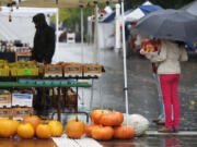 Mila Wood holds cut flowers on the soggy final day of the Vancouver Farmers Market's 2012 season on Sunday.