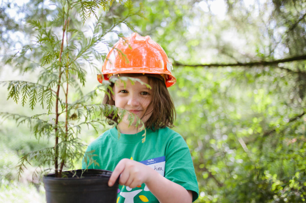 Kevanna Park: Krystina Young, daughter of Comcast direct sales representative Michelle Young, helps place native plants April 27 in Kevanna Park.