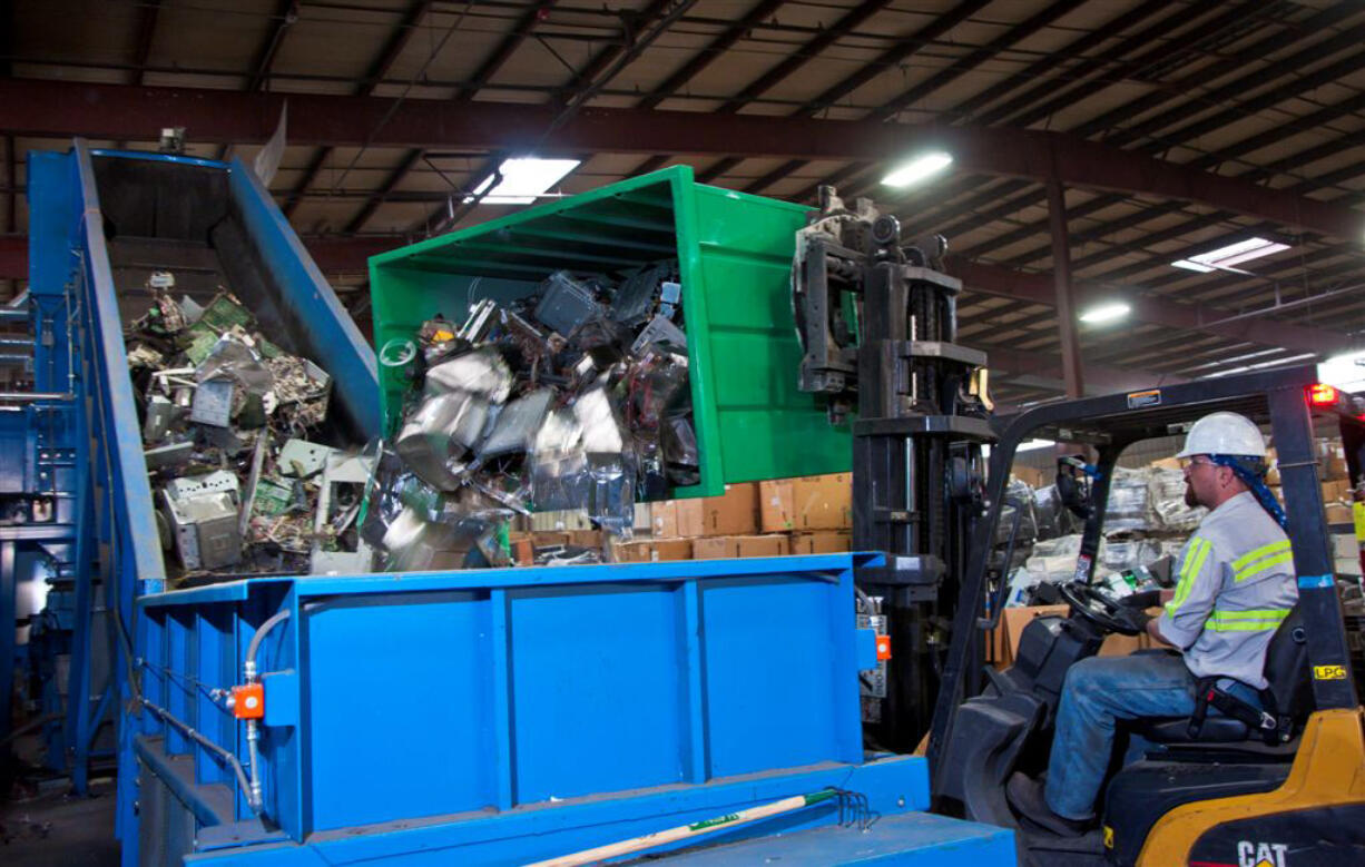 Dennis Collison of IMS Electronics Recycling dumps electronics components for recycling.