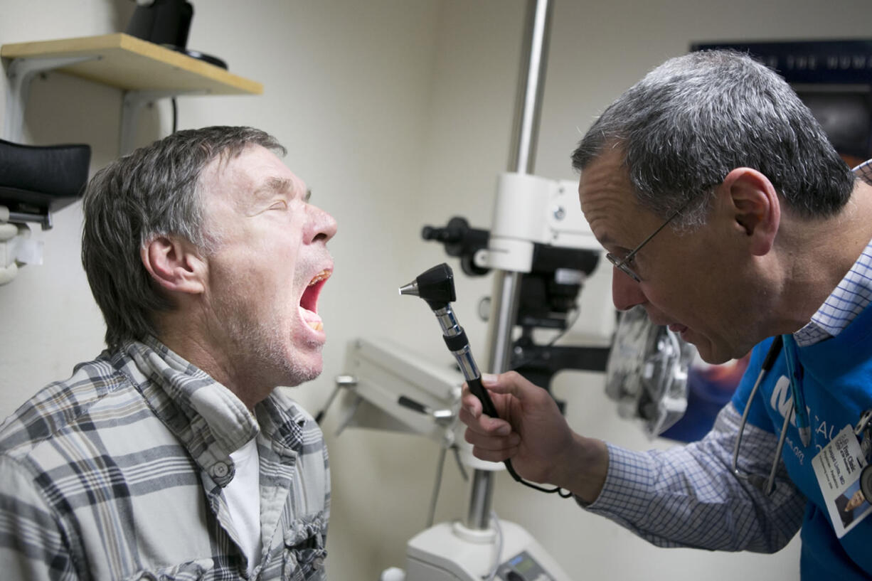 Dr. Rasjad Lints examines John Beach on Tuesday night at the Free Clinic of Southwest Washington.