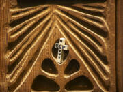 A cross is placed along with others on wooden panels March 13 at Heritage Chapel at PeaceHealth Southwest Medical Center in Vancouver.