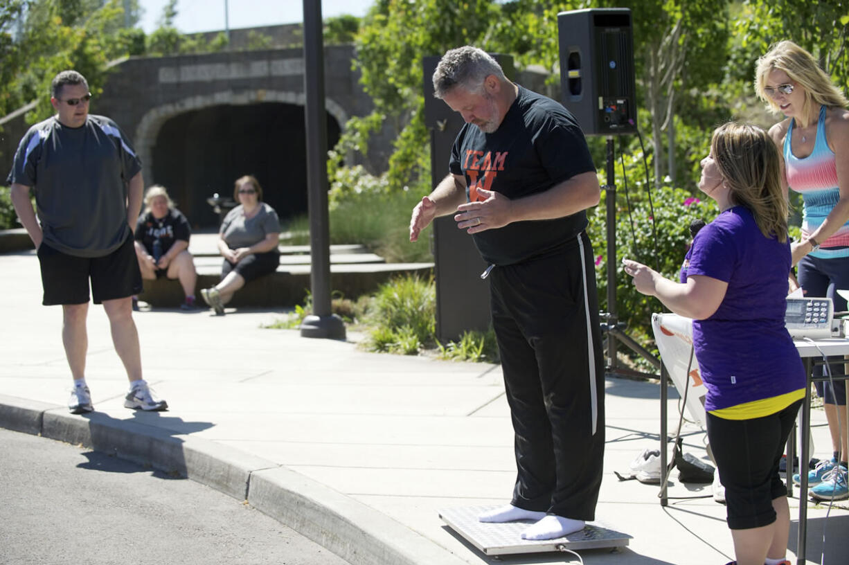 Washougal Mayor Sean Guard weighs in as Camas Mayor Scott Higgins, left, looks on Saturday at the final weigh-in for the &quot;Camas and Washougal on a Diet&quot; challenge.  Both mayors, along with 450 residents, took part in the yearlong project.