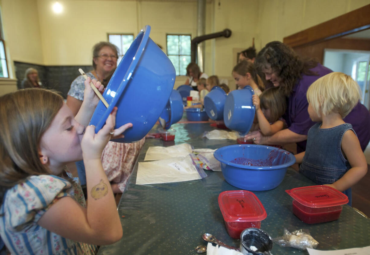 Julia Ritton, 7, of Battle Ground can't resist a taste of raspberry freezer jam that she made Sunday during Homestead Day at the Venersborg School house.