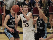 King's Way Christian forward Kienan Walter (12) looks to pass against Lynden Christian's Zach Roetcisoender (right).