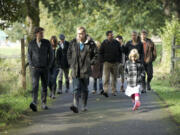 The Sturtevant Family walks along a path that winds through their 34-acre Botany Bay Farm on Oct. 3 in Brush Prairie.  The large family moved from Vancouver to the rural area in 2011 to start the farm and father Mark said everyone cheerfully chips in to help, even if there is a bit of griping at the early hours.