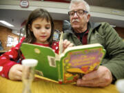 Volunteer Ralph Hutchison, right, reads a book to Abigail Potts, 6, a first-grade student at Peter S. Ogden Elementary School on Tuesday. Hutchison has been volunteering as a tutor for two years. &quot;It's very rewarding,&quot; Hutchison said.