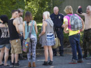 Vancouver Police Department Officer Charlie Ford talks with a group of teens on Southeast147th Avenue near Mountain View High School on Wednesday.