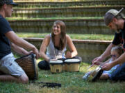 From left, Luke Alexander, 25, of Vancouver; Sarah Cayton; and Ray DeLorme, 38, of Woodland, with his daughter, Mackenzie, 2, participate in a drum circle at Water Works Park on Wednesday.