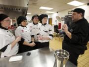 Chef R. Andrew McColley instructs students about the task of preparing 7,500 Washington-inspired hors d'oeuvres. About 30 students and McColley will deliver the food via school bus to Olympia today.