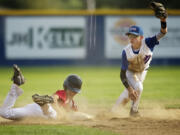 Noah Boatwright, right, of Parrish Little League lifts his glove after recording an out as Josh Mulcahey of Central Vancouver slides into second base.