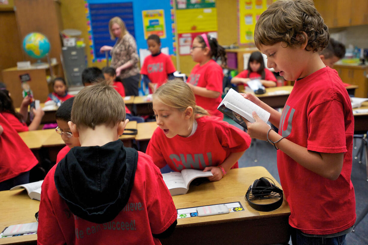 Lorenzo Gutierrez-Smith, right, flips through a dictionary which was presented by Rotarians to all the third-graders at Martin Luther King Elementary School on Wednesday.