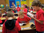 Lorenzo Gutierrez-Smith, right, flips through a dictionary which was presented by Rotarians to all the third-graders at Martin Luther King Elementary School on Wednesday.