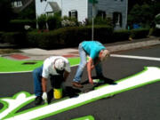 Arnada: Temperatures neared 100 degrees as neighborhood volunteers spruced up the mural at the corner of D and 22nd streets on Aug.