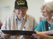 Korean War veteran Jimmie Olsen and wife of 64 years Jean Olsen, read a certificate from the South Korean government after receiving a medal at the Korean Liberation Day and Korean-U.S.