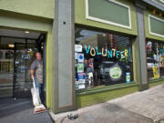 Vancouver Food Co-op volunteer Mark Henrichsen vacuums the entrance of the Main Street grocery on Friday. The sign in the window says it all: the co-op needs lots more volunteer energy to stay alive, according to board President Kirk Wright.