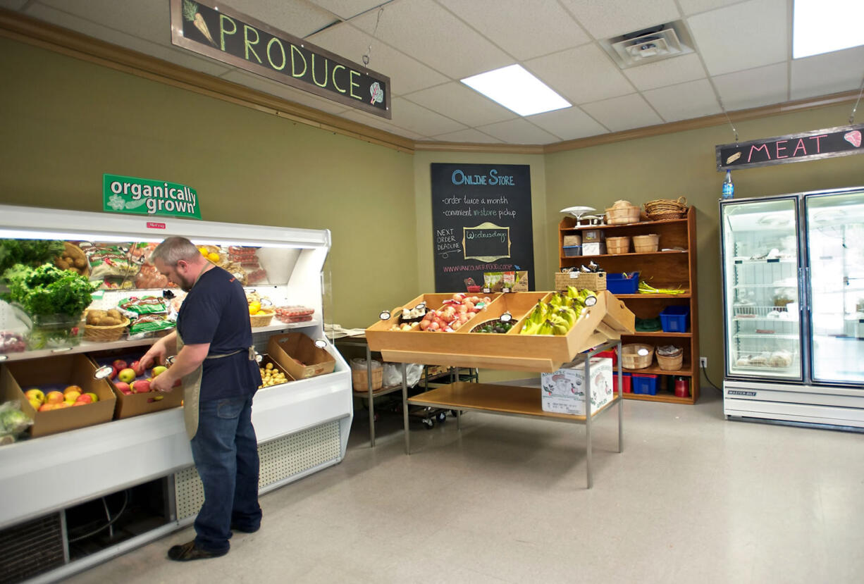 Vancouver Food Cooperative interim manager Shawn Morrill organizes the produce at the Main Street store on Oct. 11.