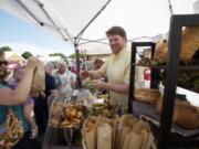 Thomas Pfandler sells baked goods Thursday at the Russell's Bread booth at the Salmon Creek Farmers' Market.