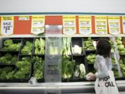 Stasha Hornbeck, a registered dietitian for Kaiser Permanente, checks out the selection of fresh greens at a WinCo Foods store in Portland last week.