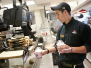 Lucas Schwartz, 17, clears an order before delivering shakes to customers as he works his shift at Burgerville on 2200 E. 4th Plain Mills Boulevard in Vancouver.