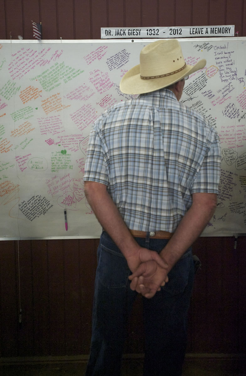 Harley Williams, who has four horses and described Jack Giesy as both a good friend and his vet for the past 16 years, reads a board of messages and memories for the longtime veterinarian Friday.