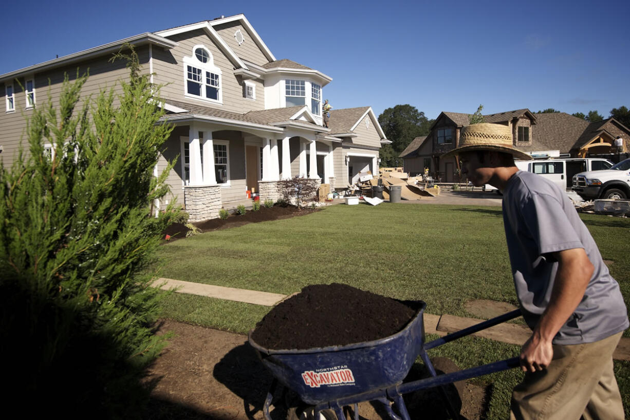 Workers landscape at a fevered pitch outside The Nantucket, built by Axiom Luxury Homes as a Parade of Homes entry.