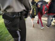 Armed guard Howard Anderson patrols South Ridge Elementary School as students are released Thursday afternoon.