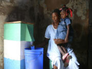 A woman pours a cup of water that has been treated by a biosand filter distributed by Chris and Leslie Rolling.