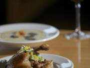 Roots Restaurant's crispy duck confit with cranberry pear bread pudding and cauliflower soup with truffle oil and sunchoke chips.