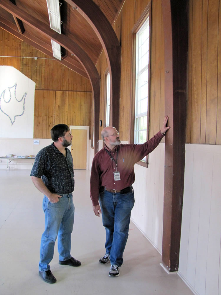 Historian Jeff Davis, left, and Memorial Lutheran Church custodian Jim Wulf examine one of the beams that would have to be braced if the former World War II Army chapel were relocated.