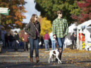 Lauren Bittner, 27, left, and Ben Churchwell, 26, walk their dog Ellie, a 3-year-old German shorthaired pointer, at the Vancouver Farmers Market on Sunday, the final day of the regular season.