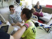 Justin Carey, 16, center, holds hands with girlfriend Lexi Davisson, 14, on July 8 at PeaceHealth Southwest Medical Center.