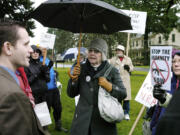 Sandra Hoyt, center, of Vancouver engages Joseph Delli Gatti, right, of Vancouver in a debate about gun control and gun rights during a rally on Tuesday outside the Vancouver office of U.S. Rep.