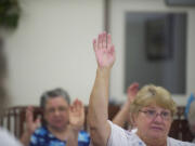 Theresa Bigford, 66, votes in favor of proposed bylaws as the new Highland Park Resident Council meets recently in Vancouver.