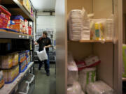 Volunteer Tim Reinhold, 26, puts together an order for a client at the North County Community Food Bank in its storeroom.