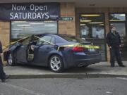 Police speak to the manager of Sterling Savings after a woman accidently drove her car through the window Wednesday afternoon.