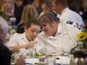 Time-tested Salvation Army client and volunteer Jackie Varner Hilby, right, chats with 11-year-old Kateresa Rowe during the charity's annual community luncheon at the Heathman Lodge on Wednesday.