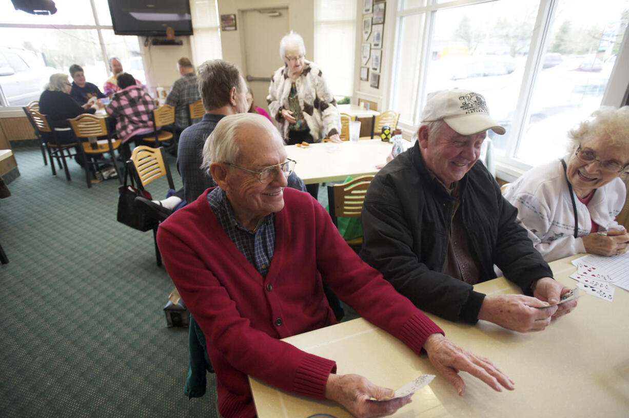 Bill Hack, left, and Doug Olson meet with the 42-Plus Singles group on Feb. 20 to play cards and dine at Round Table Pizza.