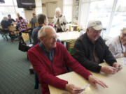 Bill Hack, left, and Doug Olson meet with the 42-Plus Singles group on Feb. 20 to play cards and dine at Round Table Pizza.