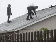 Residents survey a damaged roof one day after Battle Ground&#039;s tornado. Residents old and new couldn&#039;t think of a time they witnessed such carnage in town.