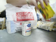 Volunteer Rebekah Papka fills a bag with food.