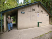 Hal Bauder, Clark County parks maintenance crew chief at Lewisville Park, examines a restroom damaged by vandals in June.