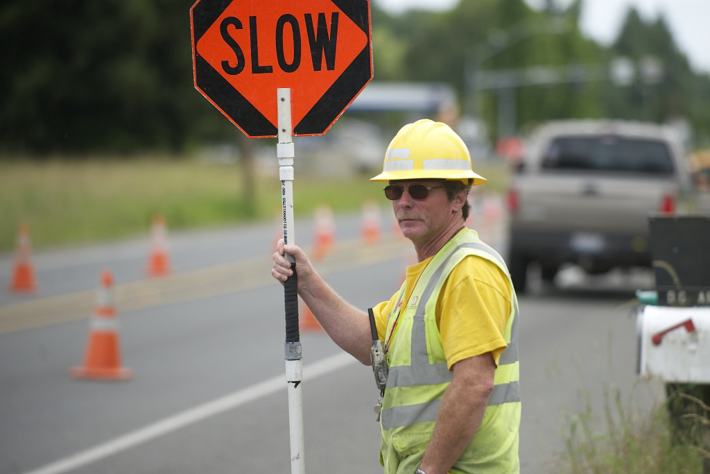 Flagger Rusty Goodson directs traffic near a utility works project on Northeast 72nd Avenue.