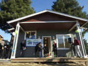 Christi Adams and her children, Cheyenne, 9, and Brendon, 7, are welcomed to their new house in Minnehaha during a Habitat for Humanity dedication ceremony Sunday.