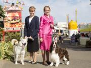 Hailey, left, with Aspyn,  and Heidi Christenson, with J,  are everywhere at the Clark County Fair. Here they pose on the midway with the dogs they show, wearing clothing they constructed and modeled.