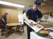 Vancouver first-year firefighter Isaac Eldred prepares coconut curry chicken for dinner at Station 2 in west Vancouver on March 1.