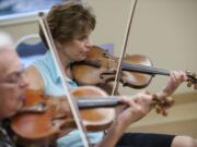 Violinists Bob Pforsich, from left, and Kathy Barry rehearse at Fairway Village.