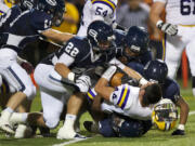 Skyview's defense smothers Columbia River's Remick Kawawaki (44), who loses his helmet but not the ball Friday.